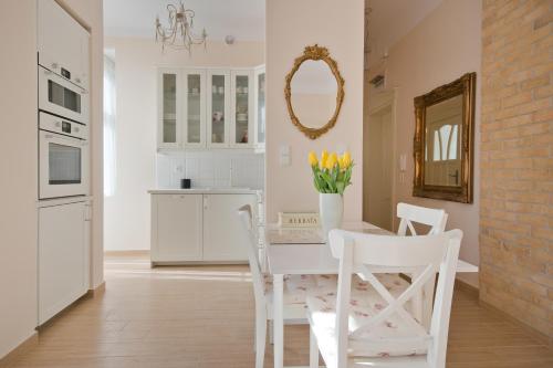 een keuken met een witte tafel en stoelen en een spiegel bij Imperial Apartments - Classic in Sopot