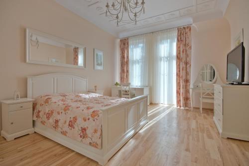 biała sypialnia z łóżkiem i komodą w obiekcie Imperial Apartments - Classic w mieście Sopot