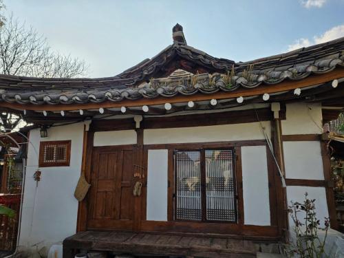 a house with a wooden door and a roof at 서라벌옛집 in Samgong