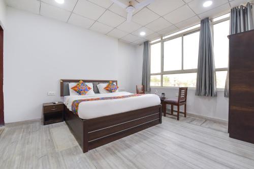 Un dormitorio con una cama y un escritorio y una ventana. en FabHotel Connect, en Jaipur