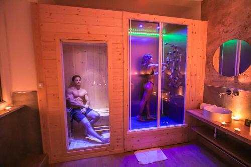 Alma Suites Livorno في ليفورنو: حمام به شخصان في غرفة بها دش