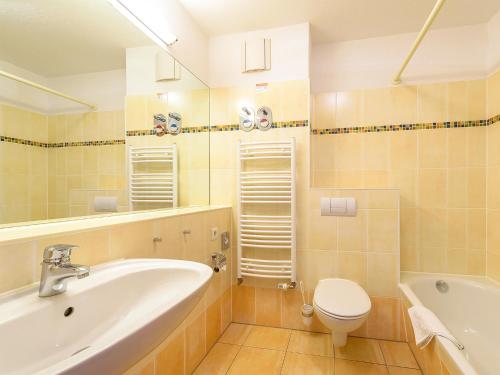 a bathroom with a sink and a toilet and a tub at Ferienwohnung mit Boddenblick - D 132.073 in Rerik