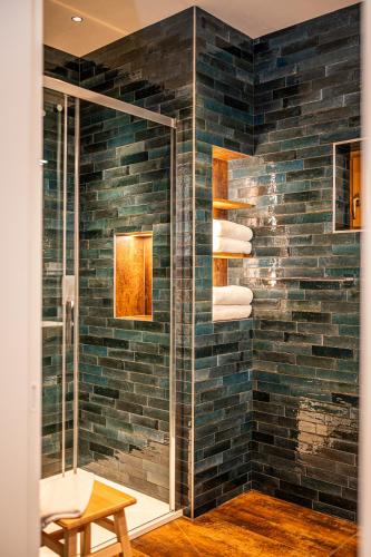 a bathroom with a brick wall with a shower at Stodola 63 in Pacov
