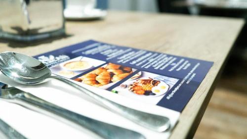 a book of food on a table with a spoon at Westend Hotel & Bar in Nairn