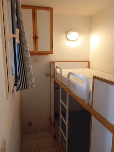 a small room with a bunk bed and a window at les pieds dans l'eau 1-Piscine chauffée in Le Barcarès
