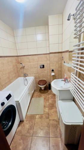 een badkamer met een bad, een wastafel en een toilet bij Makowa 2 Street in Konin