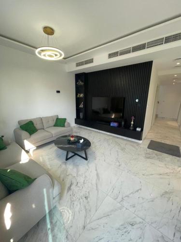 a living room with a couch and a fireplace at Dubai Hills Mahek Holiday Villa in Dubai