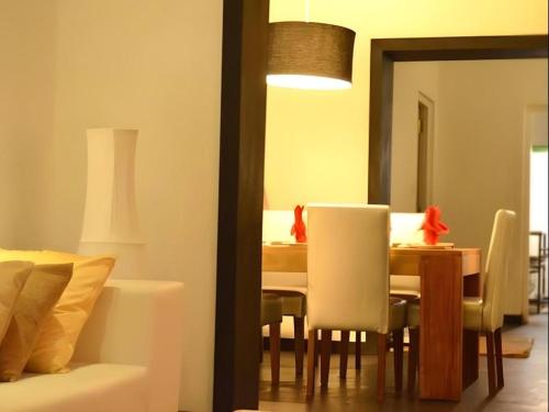 a dining room with a table and white chairs at 26 Loversleap Cottage in Nuwara Eliya