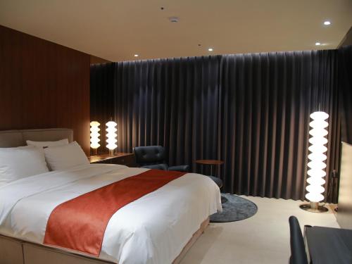 1 dormitorio con 1 cama grande, escritorio y silla en 구미 더혜밀호텔, en Gumi