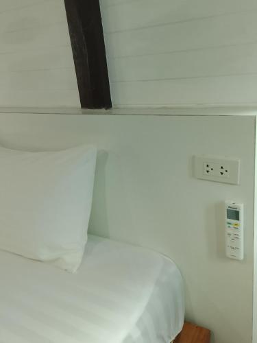a white room with a bed and an electrical outlet at DD Beach Houses in Phra Ae beach