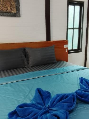 a blue bed with blue sheets and pillows on it at DD Beach Houses in Phra Ae beach