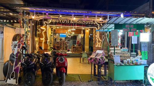 een groep scooters geparkeerd voor een winkel bij ChefJa Hotel and Restaurant 