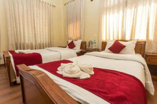 Un dormitorio con dos camas con sábanas rojas y blancas. en Hotel Norbu Sangpo, en Katmandú