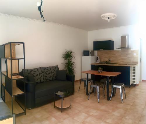 ein Wohnzimmer mit Sofa und Tisch in der Unterkunft Gîtes Villa Beau Soleil Agde in Agde