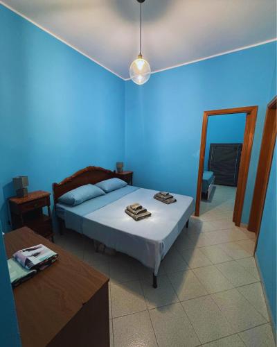 a blue bedroom with a bed and a table at GC Petit Palais Lampedusa in Lampedusa