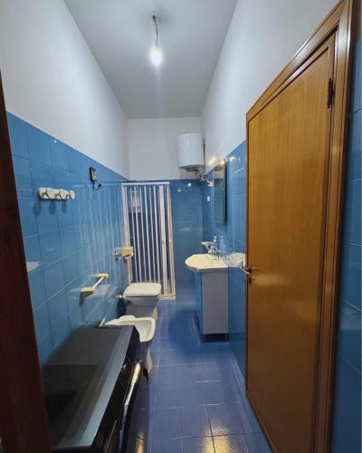 a blue bathroom with two toilets and a sink at GC Petit Palais Lampedusa in Lampedusa