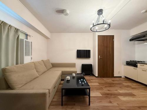 a living room with a couch and a table at Hottie - 1 Bedrm Apt 5mins from Hiroshima Sta 5ppl 302 in Hiroshima