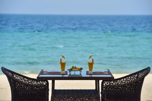 a table with two chairs on the beach at Sealine Beach, a Murwab Resort in Mesaieed