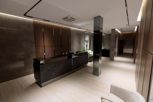 a bathroom with a vanity and a chair in a room at Velura Hotel & Spa in Ferizaj