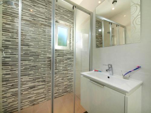 a white bathroom with a sink and a shower at Calheta 25 in Luz