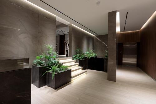 a lobby with a row of potted plants at Velura Hotel in Ferizaj