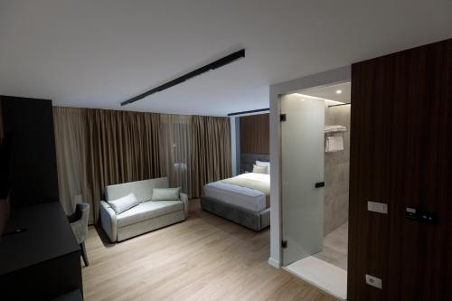 a hotel room with a bed and a chair at Velura Hotel & Spa in Ferizaj