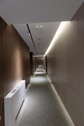 a hallway with a long corridor with lights on the walls at Velura Hotel in Ferizaj