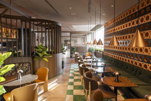 un restaurante con una fila de mesas y sillas en Scandic Stuttgart Europaviertel, en Stuttgart