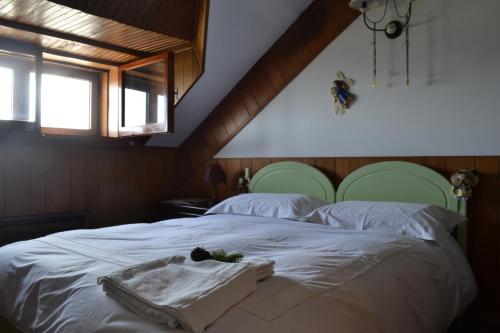 1 dormitorio con 1 cama con sábanas blancas y cabeceras verdes en Number 51 en Roccaraso