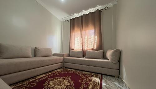 a living room with a couch and a window at Maison Luxueux et Spacieux in Oujda