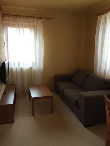 a living room with a couch and a window at Apartmán Fiona in Veľká Lomnica