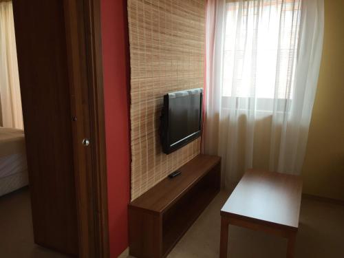 a room with a tv on a wall next to a window at Apartmán Fiona in Veľká Lomnica