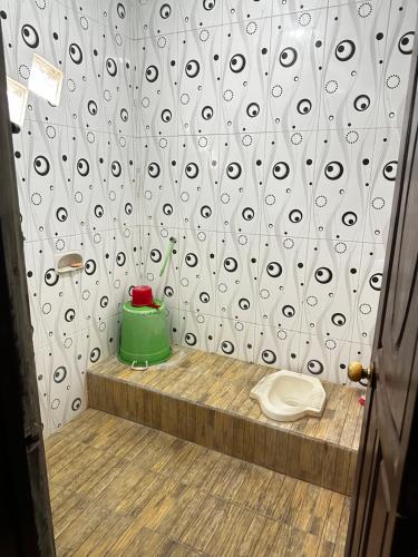 a shower stall with a green pot and a toilet at The wilsian - Syariah guest house in Sengkaling