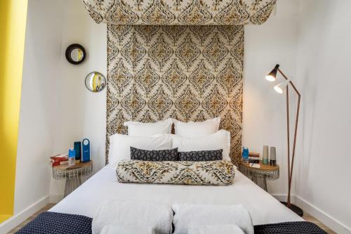 a bedroom with a large bed with white pillows at Sweet Inn - Aboukir II in Paris