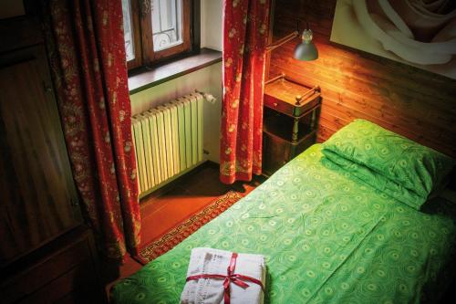 a bedroom with a green bed and a window at Maison Balan in Châtillon