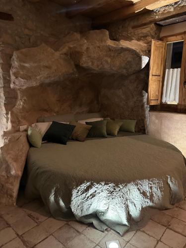 a bed in a room with a stone wall at Paolino848 in Trentinara