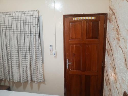 eine Holztür in einem Zimmer mit Fenster in der Unterkunft Résidence Keur Mame Seye 4 in Dakar