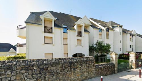 a large white building with a stone wall at Le Kervenel - Les Gîtes de la Côte d'Amour in Le Croisic