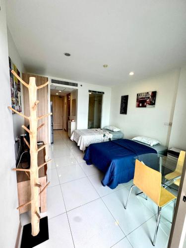 a bedroom with two beds and a glass table at Riviera Wongamat in North Pattaya