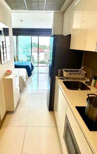 a kitchen with a sink and a bed in a room at Riviera Wongamat in North Pattaya