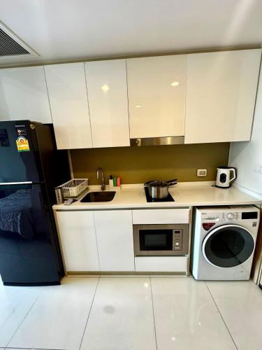 a small kitchen with a sink and a microwave at Riviera Wongamat in North Pattaya