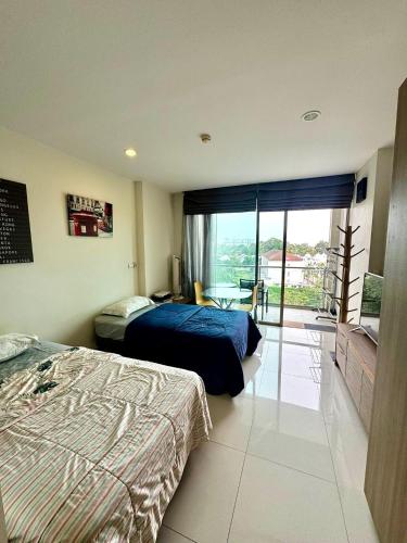 a hotel room with two beds and a balcony at Riviera Wongamat in North Pattaya
