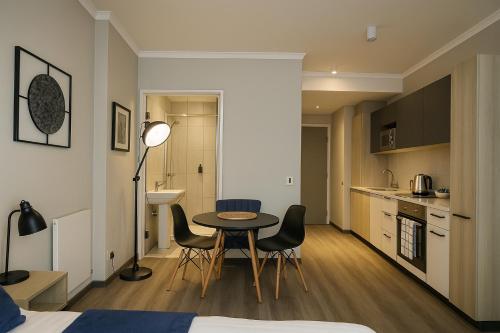 a room with a table and chairs and a kitchen at Menlyn Apartment - Studio in Pretoria