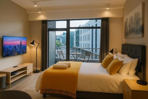 a bedroom with a large bed and a balcony at Menlyn Apartment - Studio in Pretoria