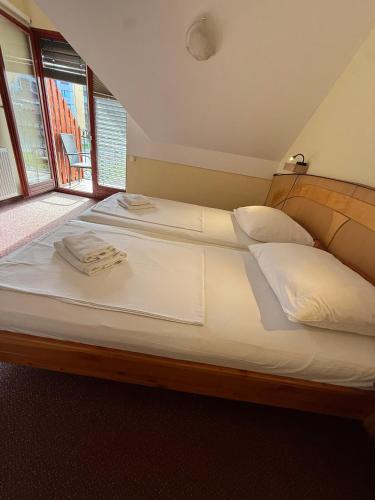 a large bed with white sheets and towels on it at Guesthouse Jurcek in Zreče