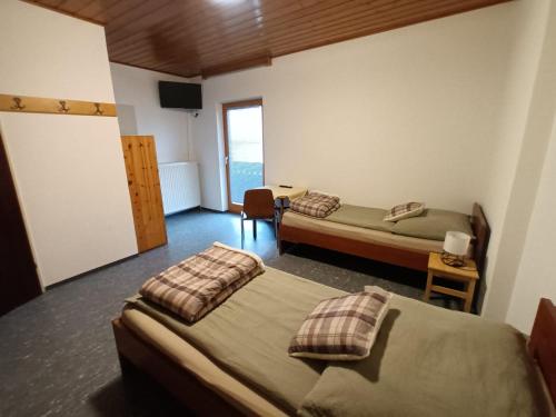 Una habitación de hotel con dos camas y un televisor. en Pension Waldfrieden, en Steinhaus am Semmering