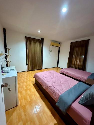 een slaapkamer met twee bedden en een houten vloer bij Light Worker Guest House room number 0 in Phra Ae beach