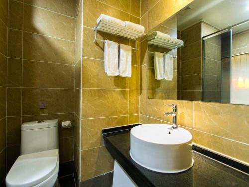 ibis Xian Lintong Huaqing Hot Spring Hotel في شيان: حمام مع حوض ومرحاض