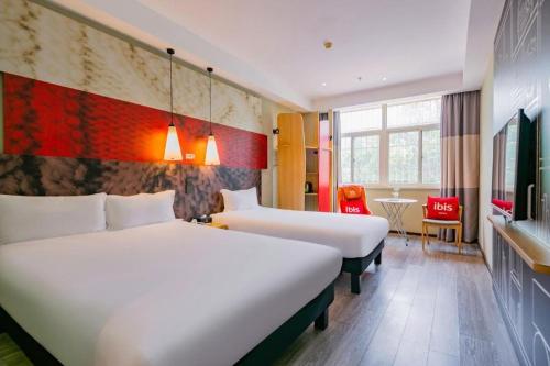 ibis Xian Lintong Huaqing Hot Spring Hotel في شيان: غرفة فندق بها سريران وطاولة