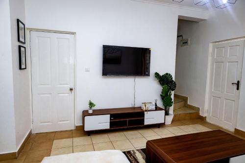 Metris Foxdale Apartments في لوساكا: غرفة معيشة مع تلفزيون بشاشة مسطحة على الحائط